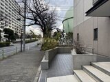 コンフォリア高島平 建物脇のアプローチから前面道路を見た共用部の様子