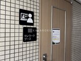 コンフォリア高島平 テレワークブース入口の案内看板と木目調ドア