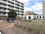コンフォリア高島平 開放的なキッズエリアと木製フェンスで囲まれた共用庭園