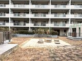 コンフォリア高島平 建物を背景に開放的なレンガ造りの共用庭園と段差式ベンチの様子