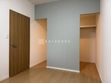 コンフォリア高島平 落ち着いた色合いのクローゼット2つと木製ドアのある洋室