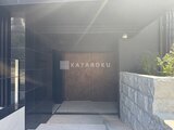 ラペルラ目黒東山2 黒いタイル張りの壁と石積みの塀がある