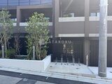 ラペルラ目黒東山2 緑を配した駐輪場と黒い門扉が特徴的な建物エントランス外観