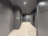 ラペルラ目黒東山2 モダンな共用廊下、明るい照明と落ち着いた色調で統一された空間