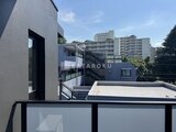 ラペルラ目黒東山2 モダンなデザインの建物外観と周辺住宅街が見える屋上空間