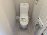 ラペルラ目黒東山2 温白色の壁と床の清潔感あるトイレ室内