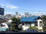 ラペルラ目黒東山2 青い瓦屋根が特徴的な建物と周辺の都市風景
