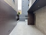 スタイリオ池上サウス 建物に囲まれたモダンな駐車スペースの奥行きのある様子