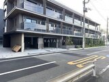 スタイリオ池上サウス 前面道路から見たモダンな建物外観と駐車場の様子