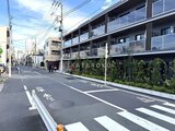 スタイリオ池上サウス 前面道路から見たモダンな建物の外観と緑化された低層部