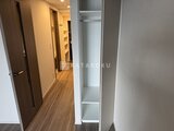 スタイリオ池上サウス 廊下に並ぶ木製ドアと収納スペースのある落ち着いた空間
