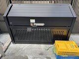 エクサム赤坂 屋外に設置された黒いエアコン室外機と黄色いコンテナ