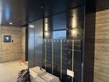 エクサム赤坂 木目調壁とブラック基調の落ち着いたエントランスホール