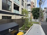 エクサム赤坂 建物前の通路に植栽を配した落ち着いた外構の様子