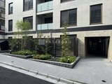 エクサム赤坂 緑を配置したモダンなエントランスと駐車場入口の様子