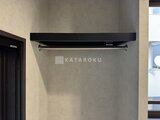 エクサム赤坂 黒いエアコン室外機を壁に設置した屋外スペース