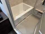 エクサム赤坂 落ち着いた色調の浴室に設置された白いバスタブと広めの浴室空間