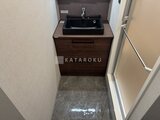 エクサム赤坂 木目調の洗面台と石調床材を備えた洗面室