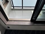 エクサム赤坂 モダンな黒枠窓から光が差し込むバルコニー