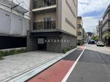 ウィーブベース上野ノース 前面道路から見たモダンなエントランスと駐車場入口の様子