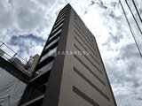 ウィーブベース上野ノース 空を背景に見上げた建物の外観と整然とした窓配列