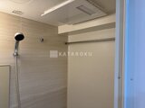 ウィーブベース上野ノース 落ち着いた色合いのタイル壁とシャワーヘッド付きのバスルーム