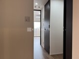 ウィーブベース上野ノース 奥のバルコニーへ続く廊下と、モダンな扉のクローゼット