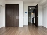 ウィーブベース上野ノース ダークブラウンの扉と木目調床が落ち着いた印象のリビング空間