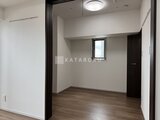 ウィーブベース上野ノース 木目調フローリングと白い壁面がモダンな居室空間