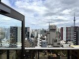 ウィーブベース上野ノース 開放的なバルコニーから眺める都市景観と空のコントラスト