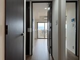 ウィーブベース上野ノース 黒枠ドアと白壁が並ぶ廊下から窓辺を眺める空間