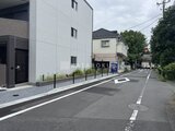 ジェノヴィア竹ノ塚 前面道路から見た白いタイル張りの建物外観