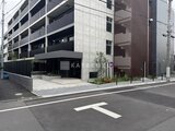 ジェノヴィア竹ノ塚 前面道路から見たモダンな外観と駐車場入口の様子