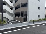 ジェノヴィア竹ノ塚 駐車場入口から見た建物外観とエントランスの様子