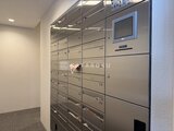 ジェノヴィア竹ノ塚 宅配ボックスと管理画面が備わった共用部のロッカー壁面