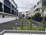 ジェノヴィア竹ノ塚 緑を配した駐車場と建物が調和した共用部の様子
