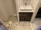 ジェノヴィア竹ノ塚 木目調の洗面台と落ち着いた色合いの床の洗面室