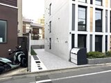 グランパセオ三宿2 街路から見た現代的なファサードと駐輪スペースのある建物入口