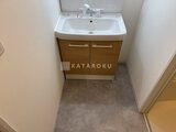 グランパセオ三宿2 木製キャビネット付きの洗面台と落ち着いた床材の洗面室