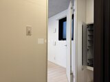 グランパセオ三宿2 明るい廊下から玄関へ続く動線と収納棚が備わった空間
