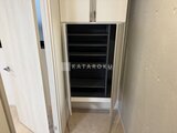 グランパセオ三宿2 玄関脇の納戸にたっぷり収納できる棚が備わった空間