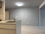 グランパセオ三宿2 明るい照明のキッチンと広がるリビングダイニング空間