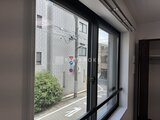 RAMIi板橋大和町 大きな窓から道路側の建物と緑が見える明るいリビング