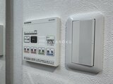 RAMIi板橋大和町 壁に取り付けられた給湯器リモコンと換気スイッチ