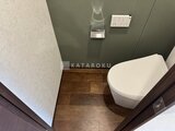 RAMIi板橋大和町 モダンなトイレ空間、落ち着いた壁色と木目調床材の組み合わせ