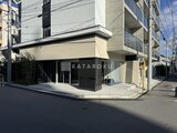 ヴィスタコート幡ヶ谷 街角に立つモダンな外観の建物1階店舗部分