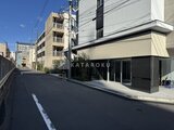 ヴィスタコート幡ヶ谷 前面道路から見たモダンな建物外観と街並みの様子