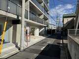 ヴィスタコート幡ヶ谷 前面道路から見た建物1階エントランスと駐車スペース
