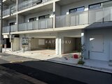 ヴィスタコート幡ヶ谷 前面道路から見た建物の1階駐車場と住宅エントランス