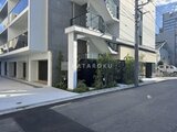 ヴィスタコート幡ヶ谷 街角に建つモダンな外観、白とグレーの配色が洗練された建物前景